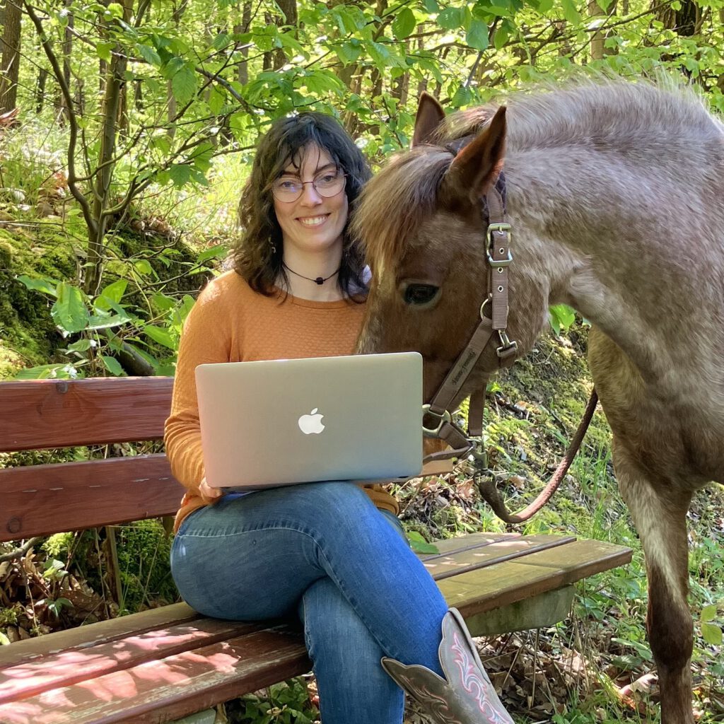 Texterin Mirjam mit ihrer Ponystute und einem Laptop
